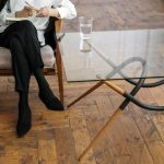 woman in white long sleeve shirt and black pants sitting on brown wooden chair