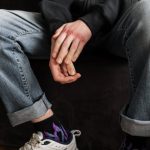 person in blue denim jeans and purple and white nike sneakers